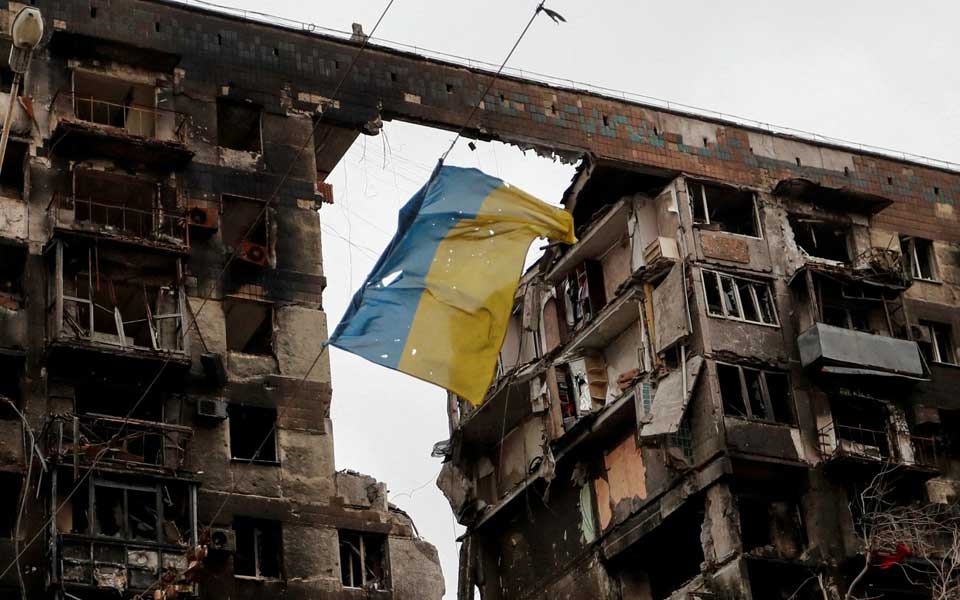 Die ukrainische Flagge weht in einem zerbombten Gebäude in Mariupol